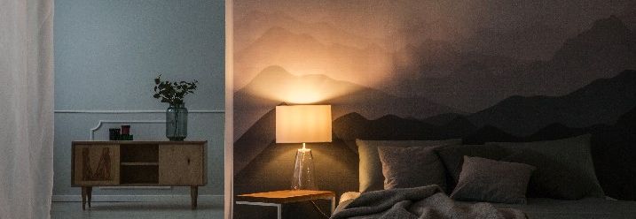 Nachttischlampe neben Bett leuchtet